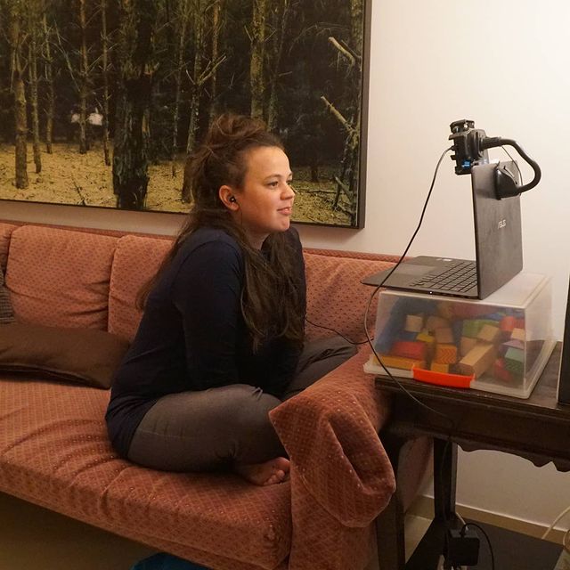 ruthy pribar in her living room wearing blue sweater and brown pant having interview in zoom